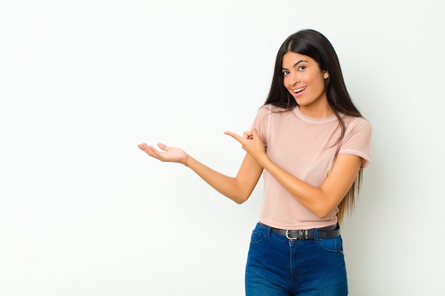 Sorrindo alegremente e apontando para copiar o espaço na palma da mão, mostrando ou anunciando um objeto