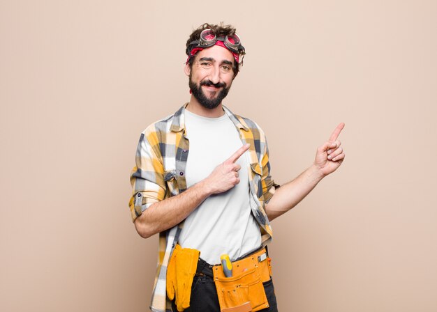 sorrindo alegremente e apontando para o lado e para cima com as duas mãos, mostrando o objeto no espaço da cópia