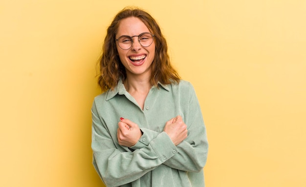 Sorrindo alegremente e celebrando com os punhos fechados e os braços cruzados sentindo-se feliz e positivo