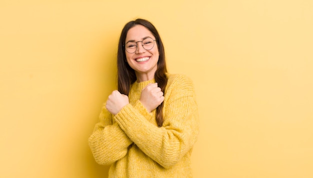 Sorrindo alegremente e comemorando com os punhos cerrados e os braços cruzados, sentindo-se feliz e positivo