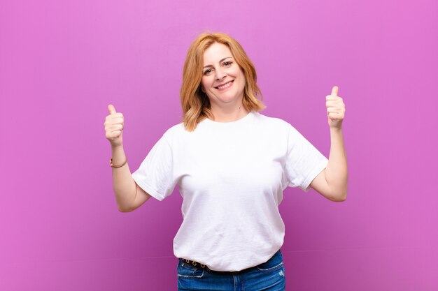 sorrindo alegremente e feliz, sentindo-se despreocupado e positivo com os dois polegares para cima