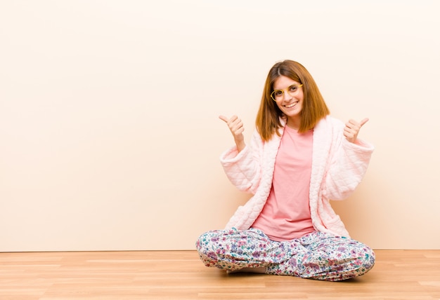 sorrindo alegremente e feliz, sentindo-se despreocupado e positivo com os dois polegares para cima