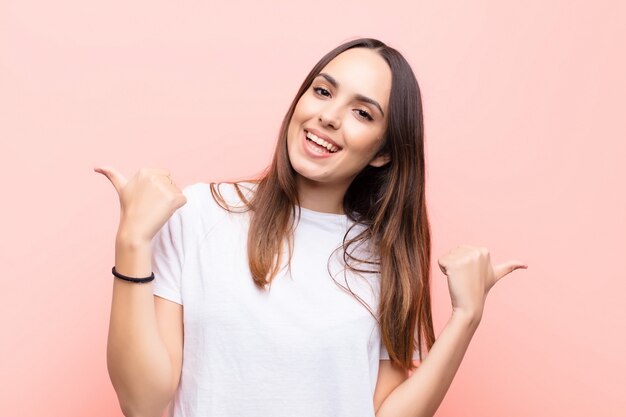 sorrindo alegremente e feliz, sentindo-se despreocupado e positivo com os dois polegares para cima