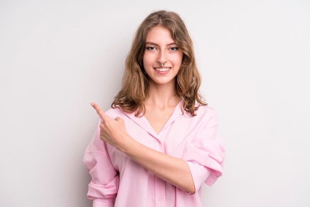 sorrindo alegremente sentindo-se feliz e apontando para o lado e para cima mostrando o objeto no espaço da cópia