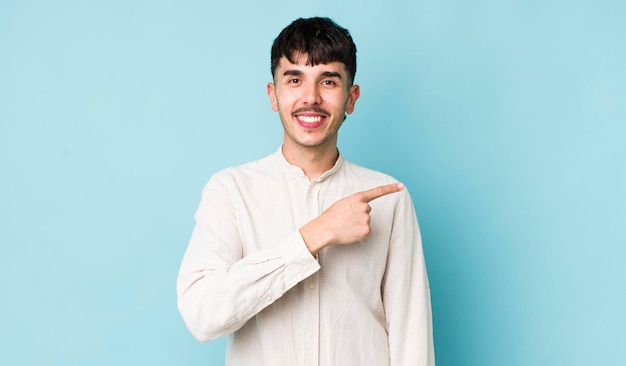 sorrindo alegremente sentindo-se feliz e apontando para o lado e para cima mostrando o objeto no espaço da cópia