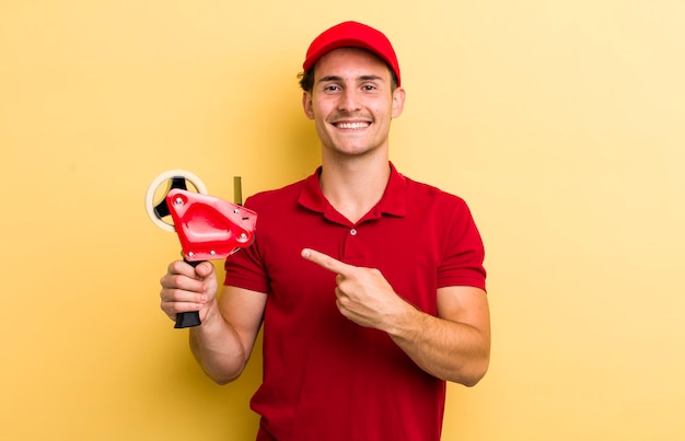 Sorrindo alegremente sentindo-se feliz e apontando para o lado