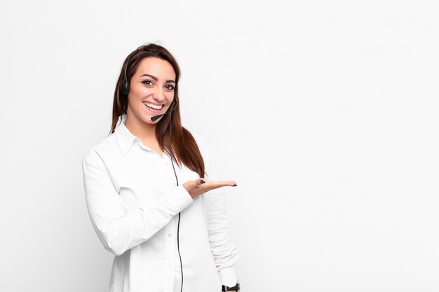 Foto sorrindo alegremente, sentindo-se feliz e mostrando um conceito no espaço da cópia com a palma da mão