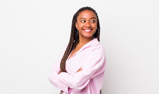 Sorrindo alegremente sentindo-se feliz satisfeito e relaxado com os braços cruzados e olhando para o lado