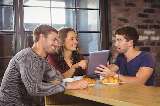 Sorrindo amigos apontando e olhando tablet