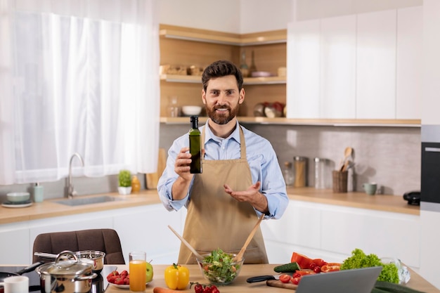 Sorrindo atraente cara caucasiano chef blogueiro em avental preparar comer recomendar garrafa de óleo