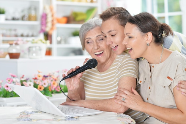 Sorrindo avó mãe e filho cantando karaokê