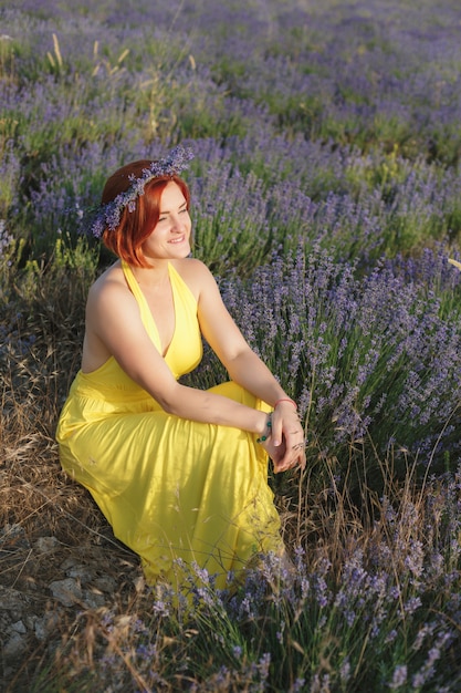 Sorrindo bela morena no campo de lavanda ao pôr do sol