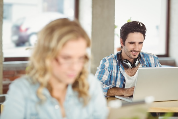 Sorrindo, bonito, negócio, homem, usando, laptop, escritório