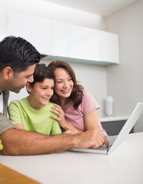 Sorrindo casal com filho usando laptop
