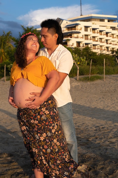 Sorrindo casal grávida na praia