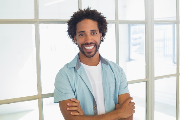 Sorrindo, casual, homem negócios, com, braços cruzaram, em, escritório