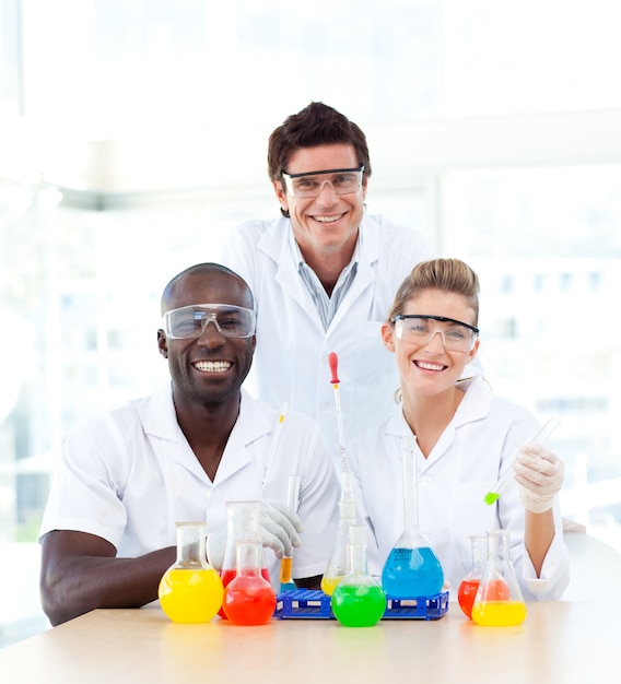 Sorrindo cientistas examinando tubos de ensaio