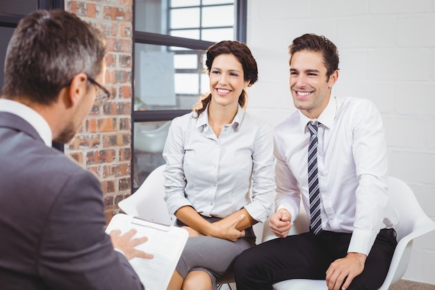 Sorrindo colegas discutindo com profissionais de negócios