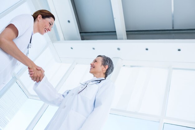 Sorrindo colegas médicos apertando as mãos