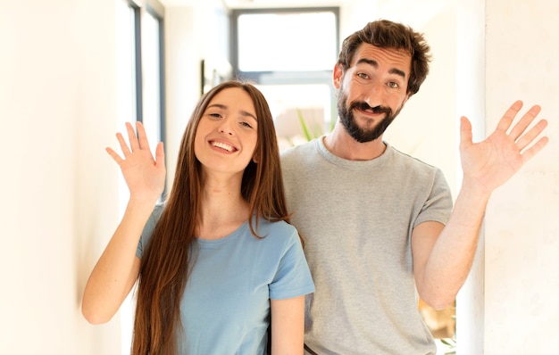 sorrindo com alegria e alegria, acenando com a mão, dando as boas-vindas e cumprimentando você ou dizendo adeus