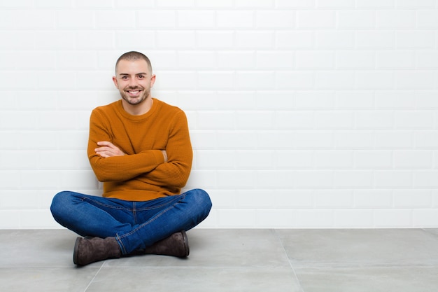 sorrindo com os braços cruzados e uma expressão feliz, confiante e satisfeita, vista lateral