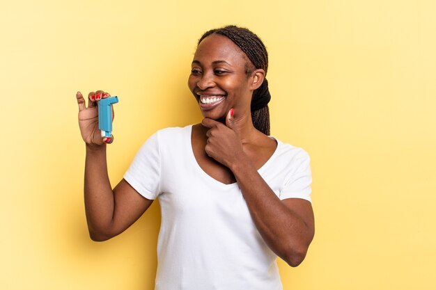 Sorrindo com uma expressão feliz e confiante com a mão no queixo, pensando e olhando para o lado. conceito de asma