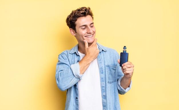 Sorrindo com uma expressão feliz e confiante com a mão no queixo, pensando e olhando para o lado. conceito de vaporizador