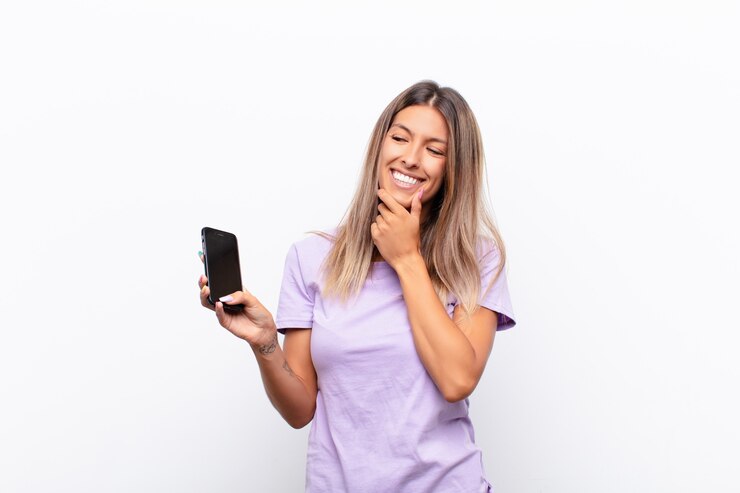 Foto sorrindo com uma expressão feliz e confiante com a mão no queixo, pensando e olhando para o lado