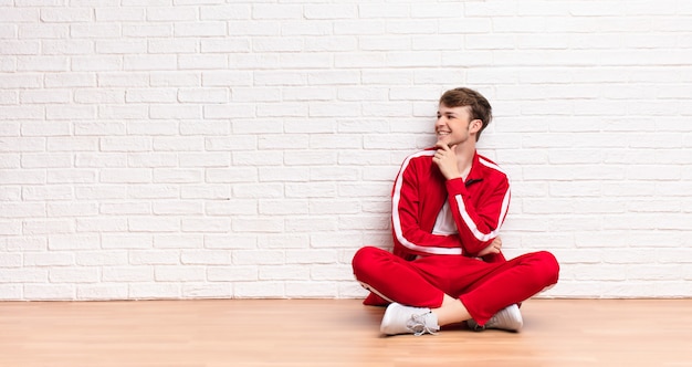 sorrindo com uma expressão feliz e confiante com a mão no queixo, pensando e olhando para o lado