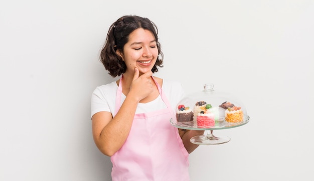 Sorrindo com uma expressão feliz e confiante com a mão no queixo