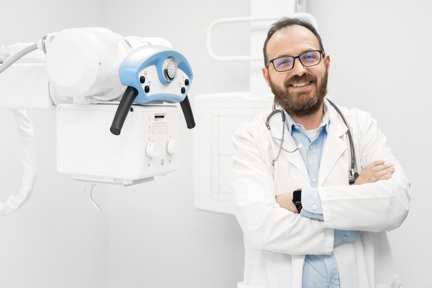 Sorrindo confiante radiologista em pé perto de equipamento de raio-x