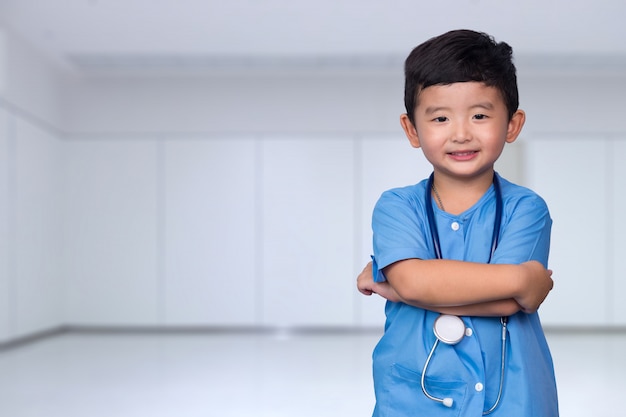 Sorrindo, criança asian, em, azul, uniforme médico, segurando, estetoscópio