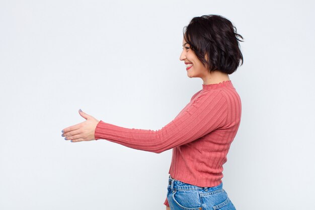 Sorrindo, cumprimentando-o e oferecendo um aperto de mão para fechar um negócio bem-sucedido