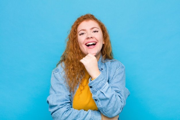 sorrindo, curtindo a vida, sentindo-se feliz, amigável, satisfeito e despreocupado com a mão no queixo