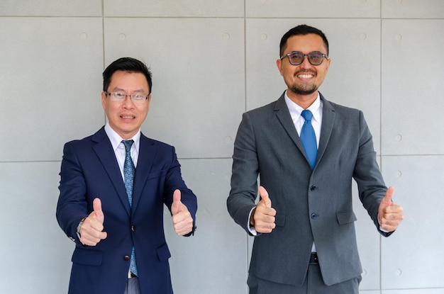 Sorrindo dois homens de negócios com polegares para cima