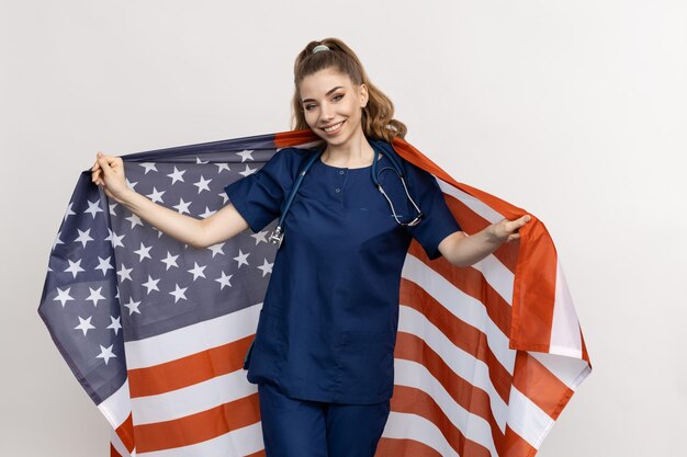 Sorrindo Doutor patriota com a bandeira da América nas costas O conceito do sistema médico dos EUA