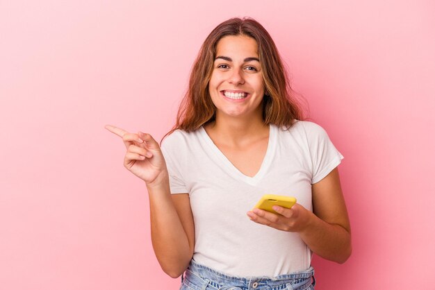 Sorrindo e apontando de lado mostrando algo no espaço em branco