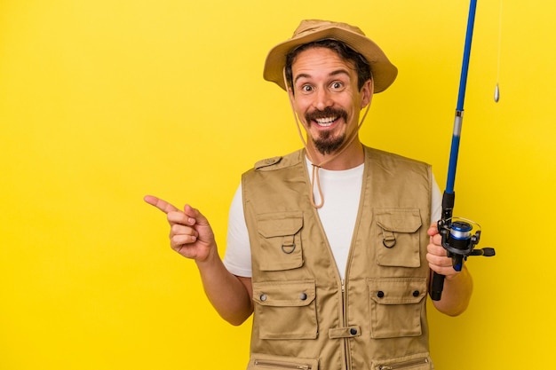 Sorrindo e apontando de lado mostrando algo no espaço em branco