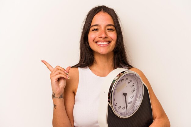 Sorrindo e apontando de lado mostrando algo no espaço em branco