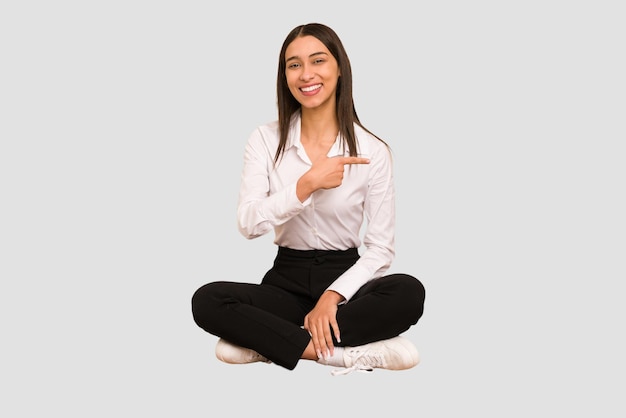 Sorrindo e apontando de lado mostrando algo no espaço em branco