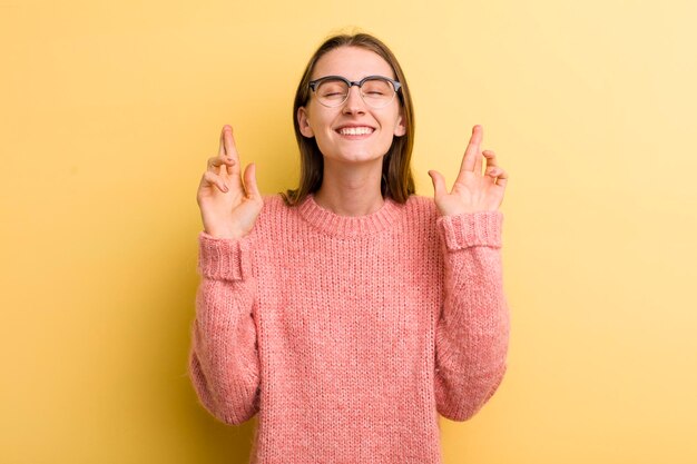 Sorrindo e cruzando ansiosamente os dois dedos sentindo-se preocupado e desejando ou esperando boa sorte