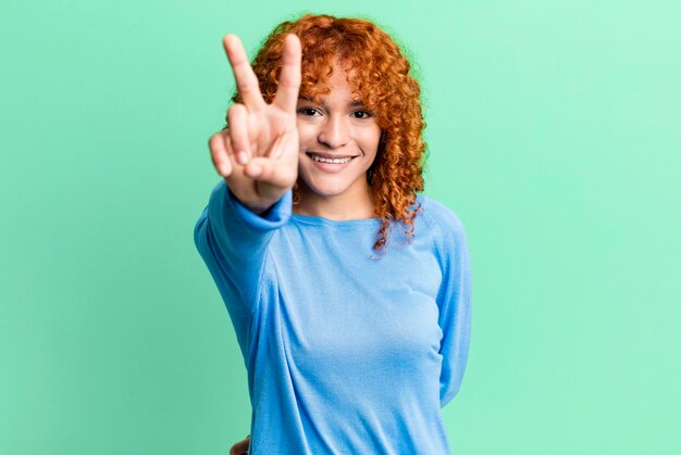 Foto sorrindo e olhando feliz vitória despreocupada e gesticulando positivo ou paz com uma mão