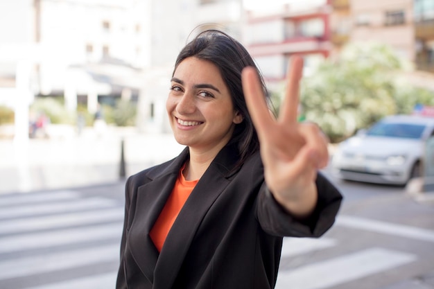 sorrindo e olhando feliz vitória despreocupada e gesticulando positivo ou paz com uma mão