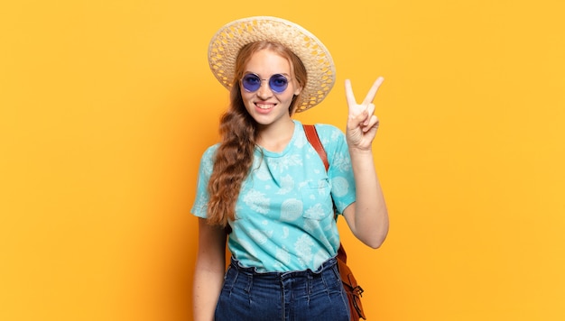 sorrindo e parecendo amigável, mostrando o número dois ou o segundo com a mão para a frente, em contagem regressiva