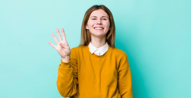 Sorrindo e parecendo amigável mostrando o número quatro ou quarto com a mão em contagem regressiva