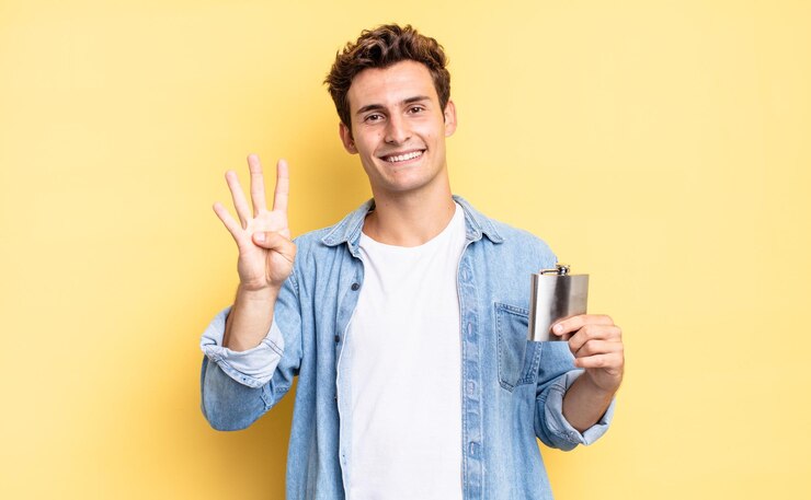 Foto sorrindo e parecendo amigável, mostrando o número quatro ou quarto com a mão para a frente, contando o conceito de frasco de álcool