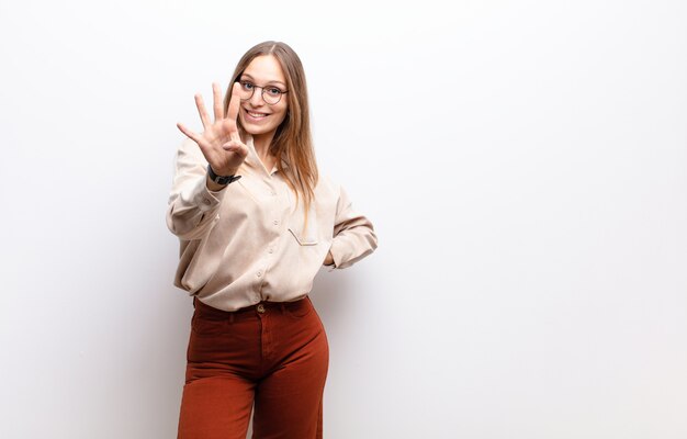 sorrindo e parecendo amigável, mostrando o número quatro ou quarto com a mão para a frente, contando