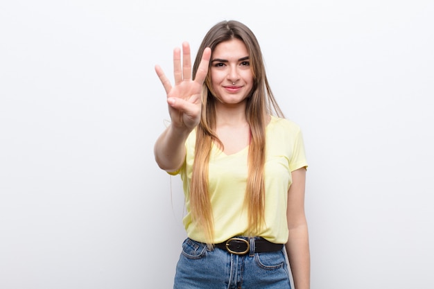 sorrindo e parecendo amigável, mostrando o número quatro ou quarto com a mão para a frente, contando