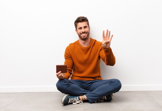 sorrindo e parecendo amigável, mostrando o número quatro ou quarto com a mão para a frente, contando