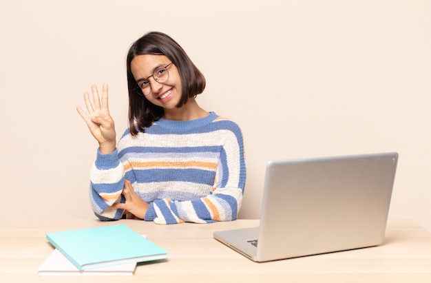 sorrindo e parecendo amigável, mostrando o número quatro ou quarto com a mão para a frente, em contagem regressiva